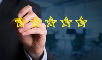 Review increase rating performance and classification concept. Businessman draw five yellow stars to increase rating of his company office in background.